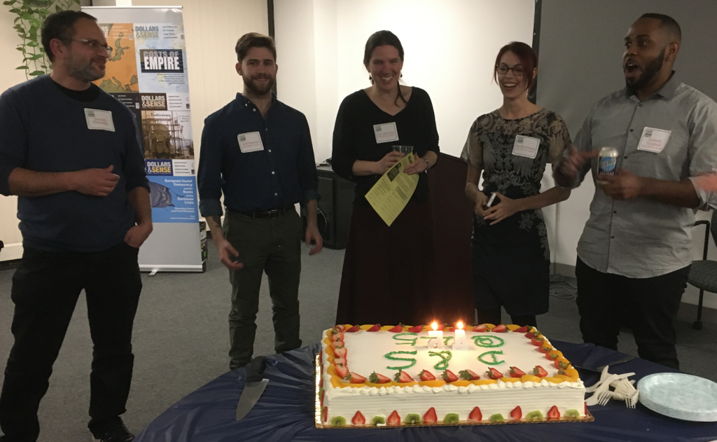Former staff member Dan Fireside and current collective members Will Beaman, Zoe Sherman, Sarah Cannon, and Cadwell Turnbull sing "Happy Birthday" to D&S. 
