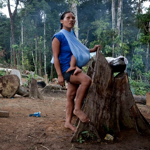 A Waorani woman with baby in Yawepare. Some Waorani are disillusioned with the oil industry’s ability to lift people out of poverty, fear environmental effects, and wish to profit from sustainable tourism. Others hope the oil industry will bring sorely needed jobs and money.